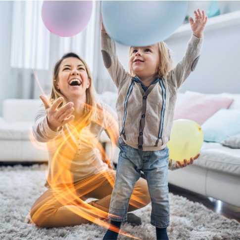Mutter und Kind spielen mit Ballon Wohnzimmer glücklich Energie Dynamisan
