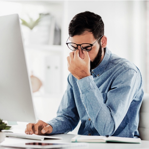 Homme devant ordinateur lunettes fatigue épuisement poste de travail bureau